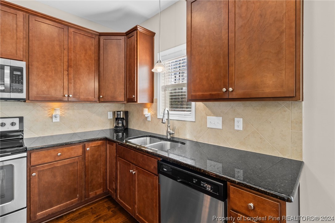 6817 Hunters Den Road Hope Mills, NC 28348 - Photo 12 of 49 a kitchen with stainless steel appliances granite countertop wooden cabinets a sink and dishwasher