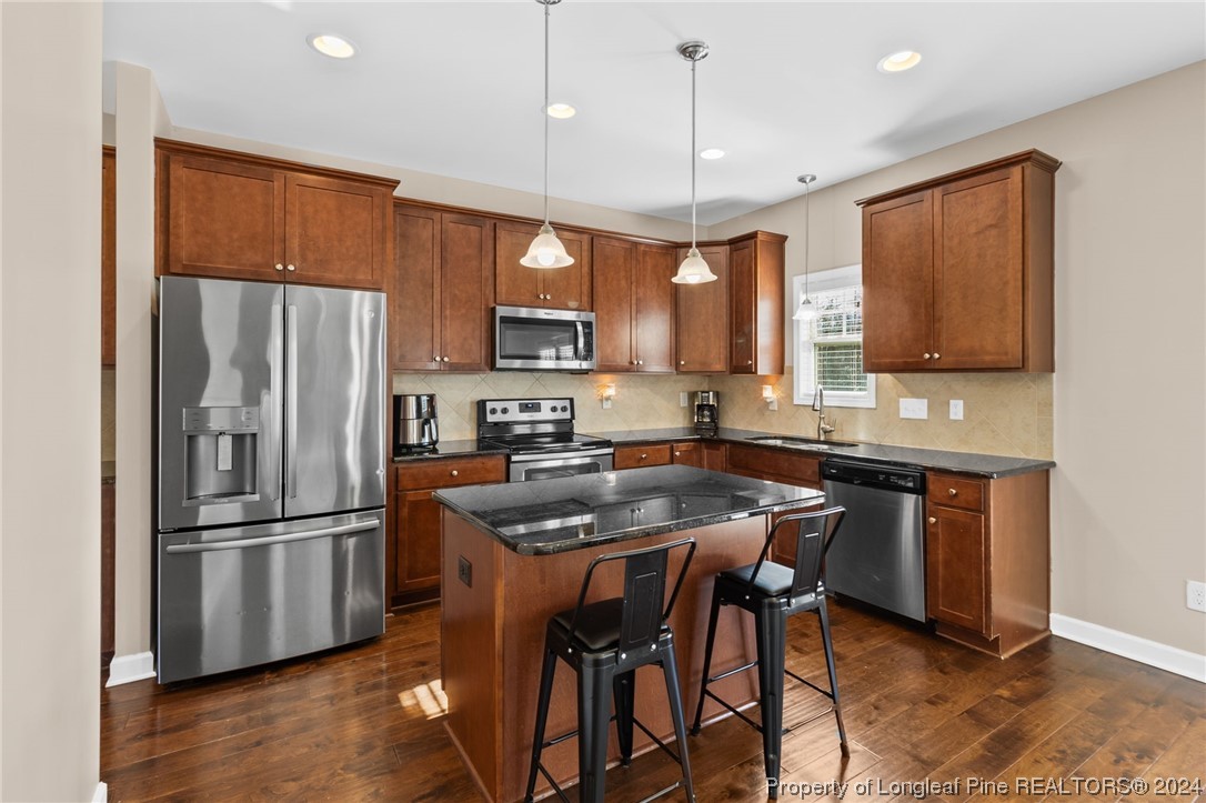 6817 Hunters Den Road Hope Mills, NC 28348 - Photo 13 of 49 a kitchen with stainless steel appliances granite countertop a refrigerator and a stove top oven