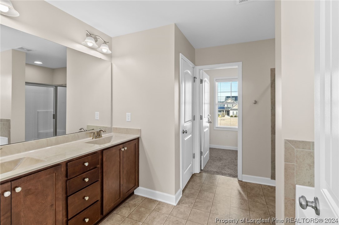 6817 Hunters Den Road Hope Mills, NC 28348 - Photo 27 of 49 a spacious bathroom with a granite countertop sink mirror and a
