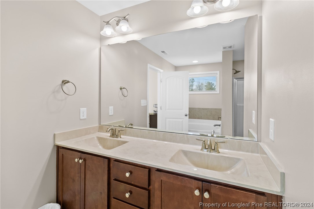 6817 Hunters Den Road Hope Mills, NC 28348 - Photo 28 of 49 a bathroom with a sink double vanity and a mirror