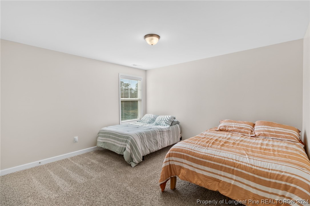 6817 Hunters Den Road Hope Mills, NC 28348 - Photo 32 of 49 a bedroom with two beds and a window
