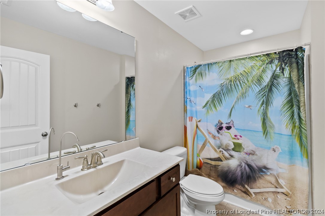 6817 Hunters Den Road Hope Mills, NC 28348 - Photo 34 of 49 a bathroom with a sink toilet and a mirror