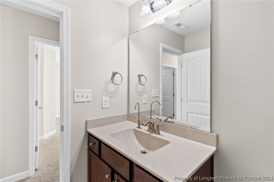 6817 Hunters Den Road Hope Mills, NC 28348 - Photo 35 of 49 a bathroom with a sink vanity and a mirror