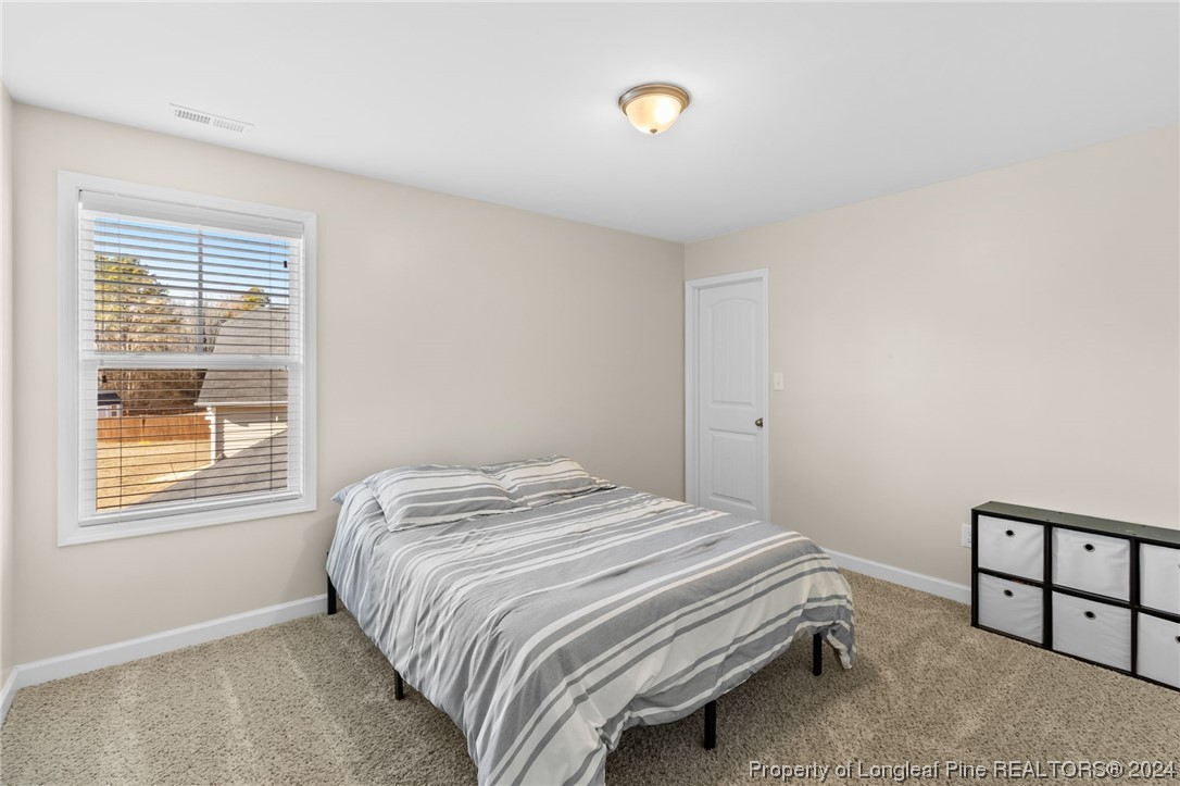 6817 Hunters Den Road Hope Mills, NC 28348 - Photo 36 of 49 a bedroom with a bed and a window