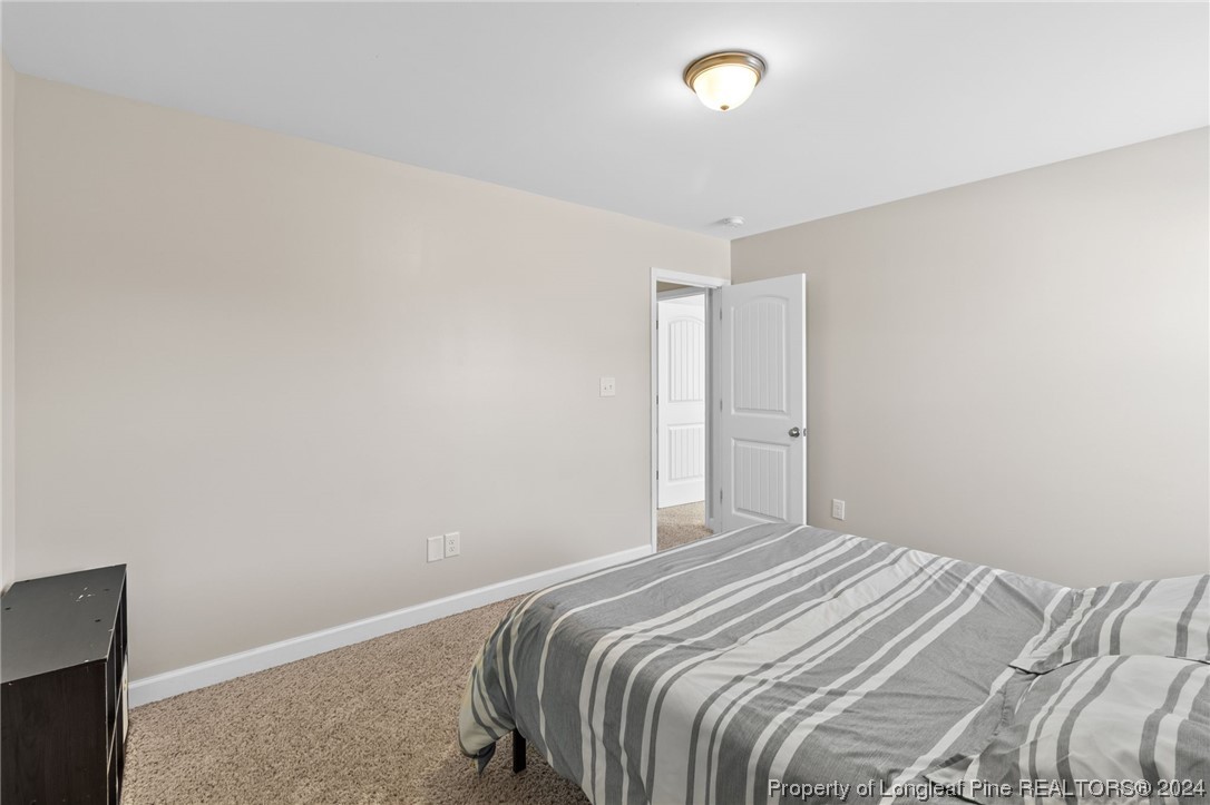 6817 Hunters Den Road Hope Mills, NC 28348 - Photo 37 of 49 a bedroom with a bed and a night stand