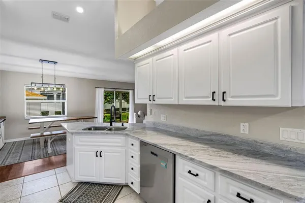 a kitchen with granite countertop white cabinets and white appliances