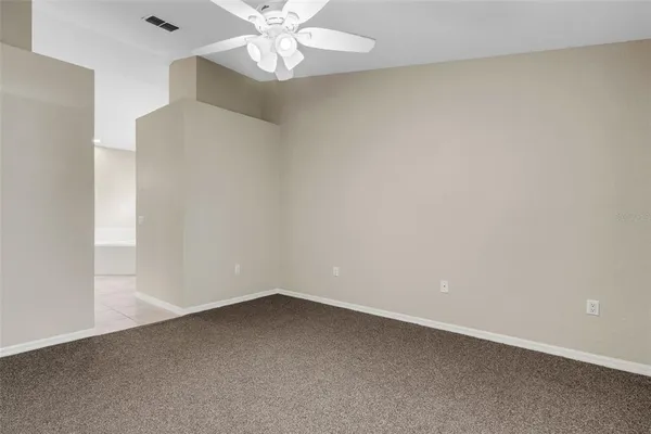 an empty room with a window and a fan