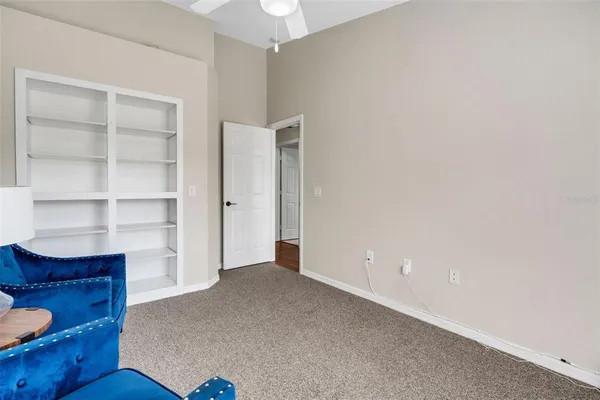 a view of an empty room with cabinet and door
