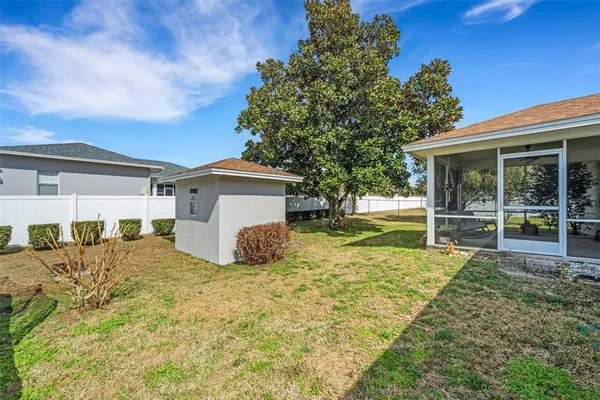 a view of a house with a backyard and a tree