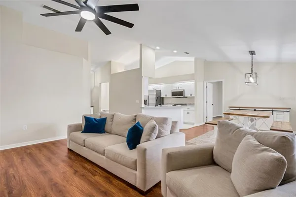 a living room with furniture and a view of kitchen