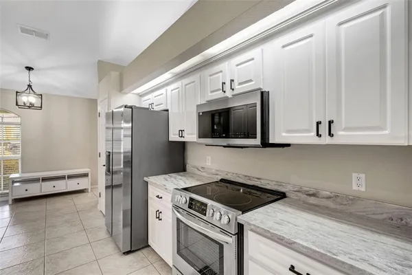 a kitchen with stainless steel appliances a sink a stove a microwave and cabinets