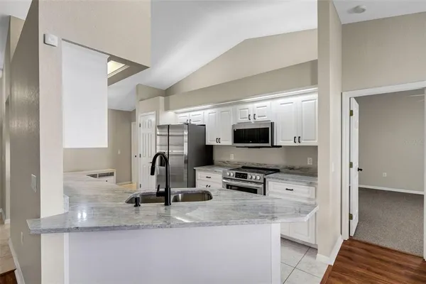 a kitchen with stainless steel appliances granite countertop a sink a stove and a refrigerator