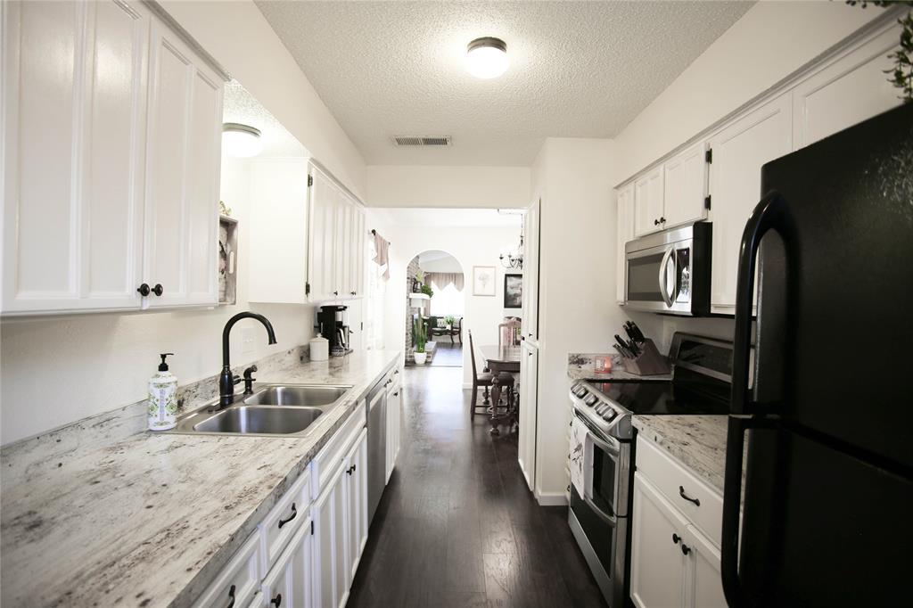 1720 Crystal Way Plano, TX 75074 - Photo 15 of 32 a kitchen with stainless steel appliances granite countertop a sink stove refrigerator and cabinets