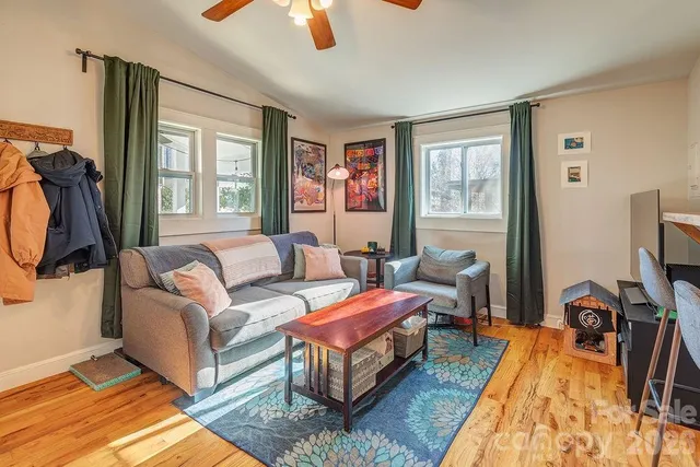 a living room with furniture a flat screen tv and a window