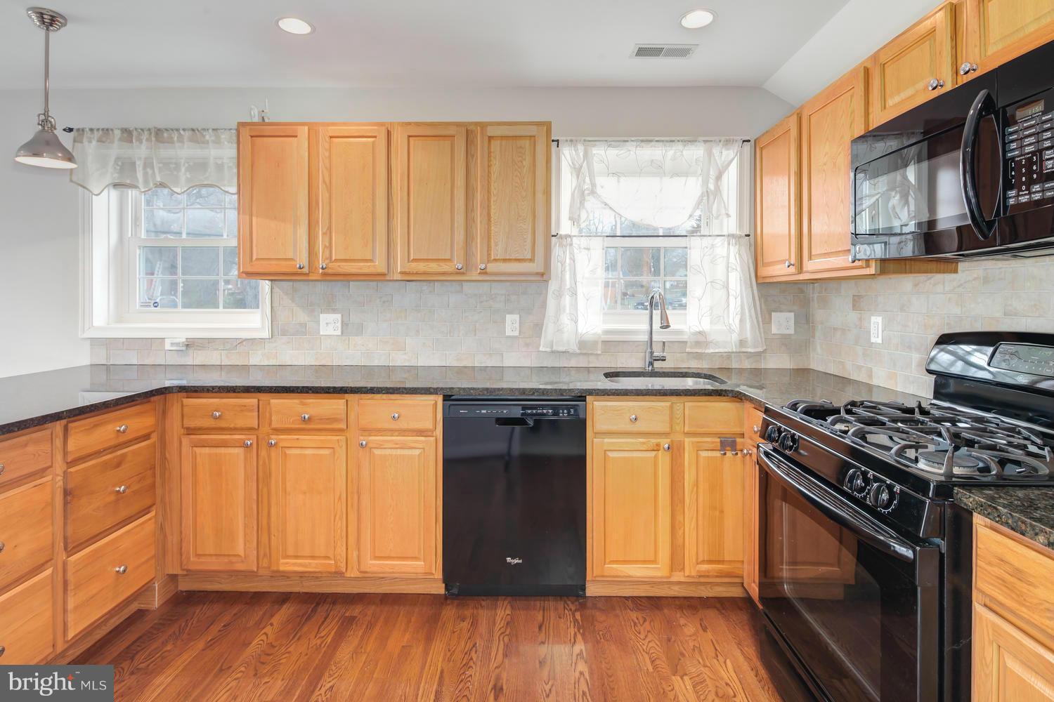 12601 Denley Road Silver Spring, MD 20906 - Photo 12 of 30 a kitchen with stainless steel appliances granite countertop wooden cabinets a stove a sink and a window