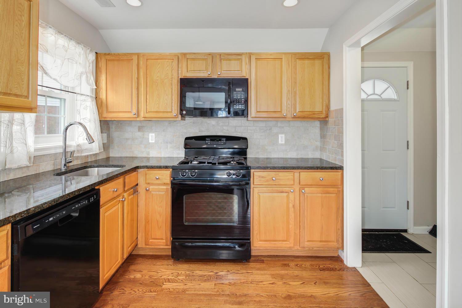 12601 Denley Road Silver Spring, MD 20906 - Photo 13 of 30 a kitchen with stainless steel appliances granite countertop a stove a sink and a microwave