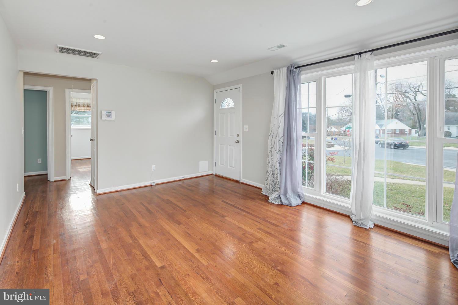 12601 Denley Road Silver Spring, MD 20906 - Photo 3 of 30 a view of empty room with wooden floor and floor to ceiling window