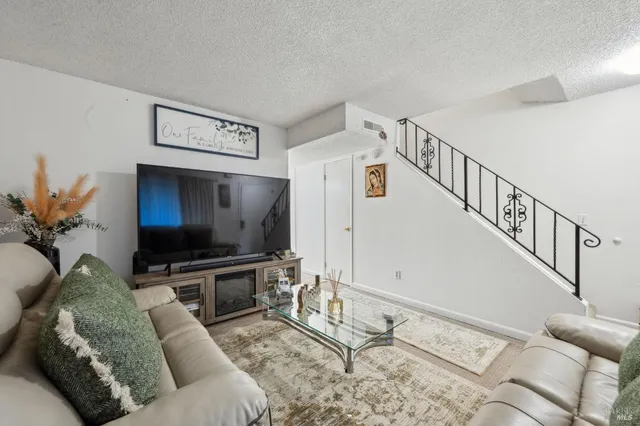 a living room with furniture and stairs