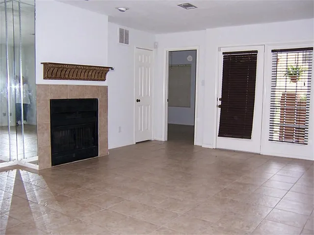 a view of an empty room with a fireplace and a window
