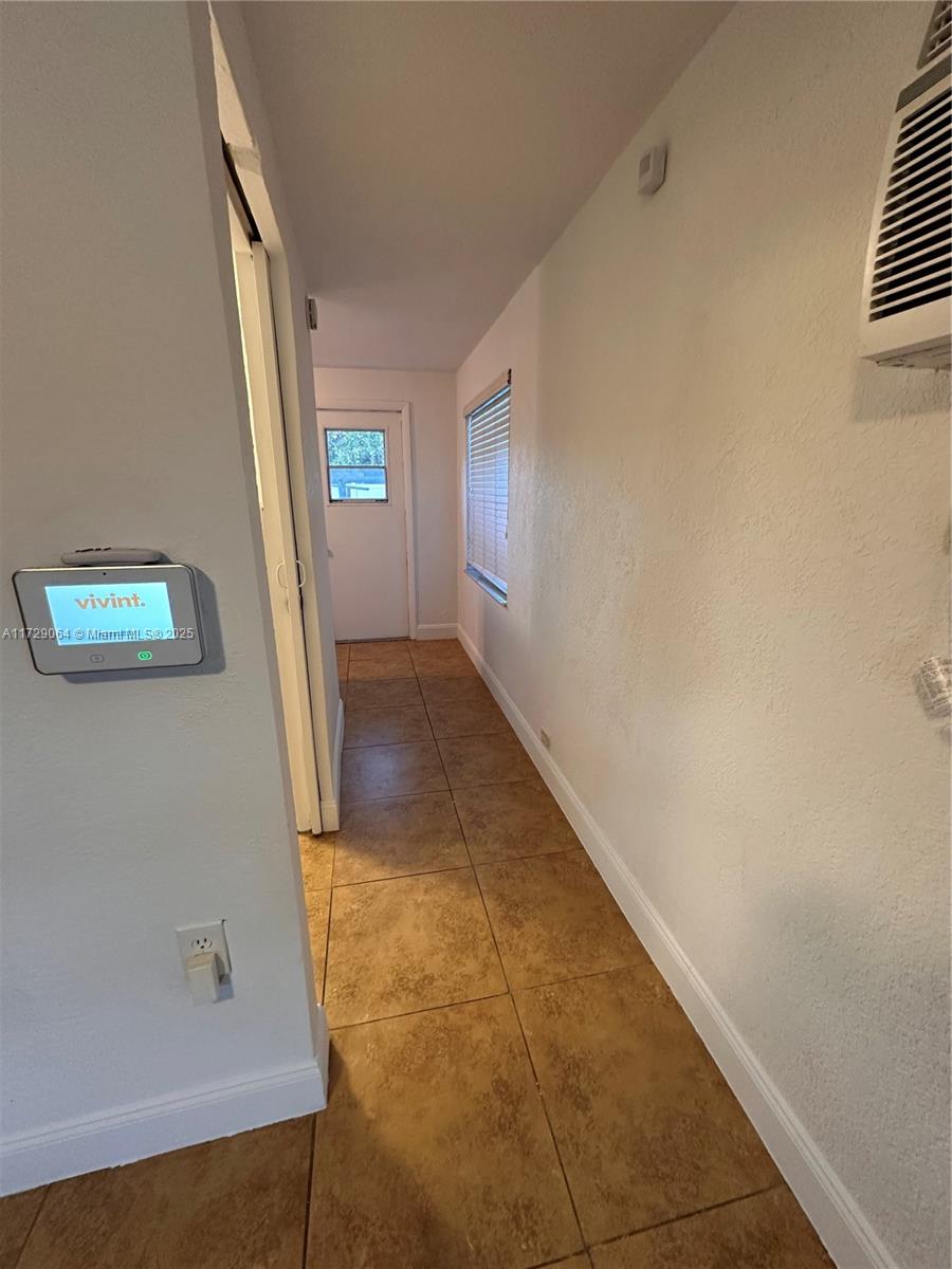 6131 Southwest 39th Street, Unit EAST Miramar, FL 33023 - Photo 11 of 15 a view of a hallway with wooden floor and a bathroom