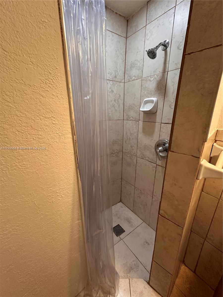 6131 Southwest 39th Street, Unit EAST Miramar, FL 33023 - Photo 8 of 15 a bathroom with a shower and toilet