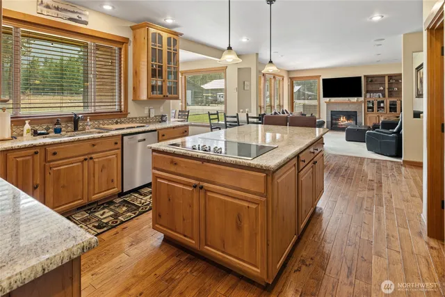 a kitchen with stainless steel appliances granite countertop a sink a stove and a wooden floors