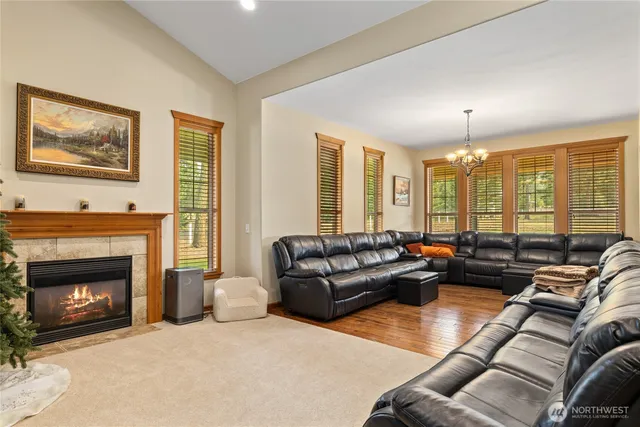 a living room with furniture fireplace and large windows