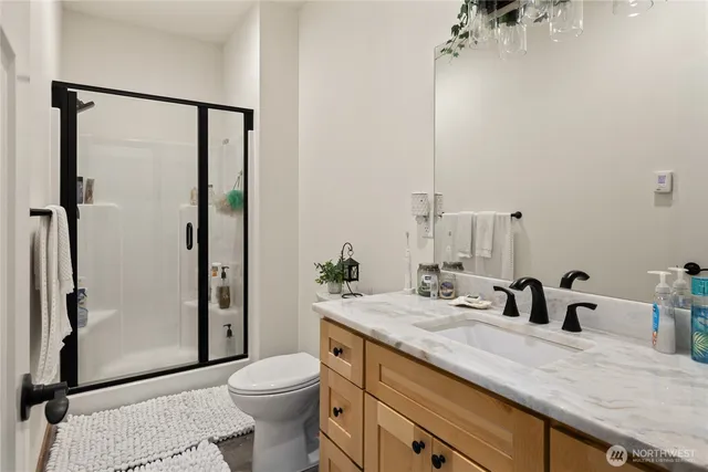 a bathroom with a granite countertop sink toilet and shower