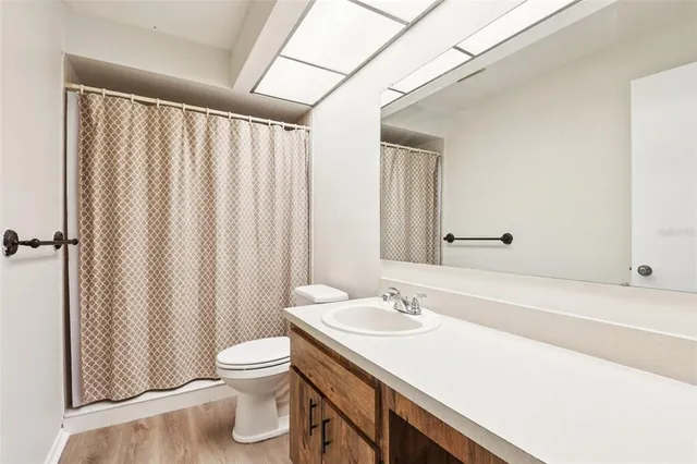a bathroom with a sink a toilet and shower curtain