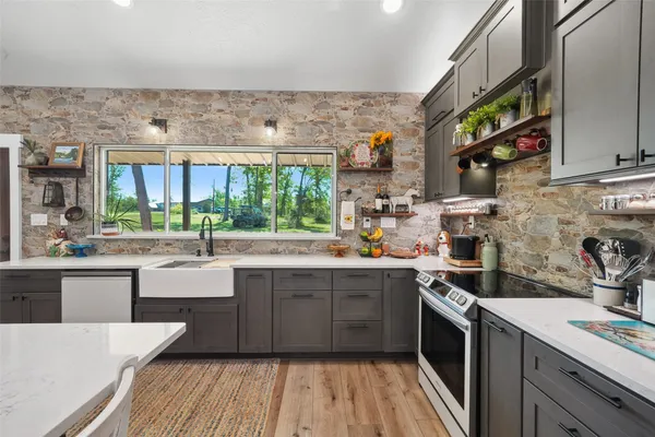 a kitchen with stainless steel appliances a sink stove and cabinets