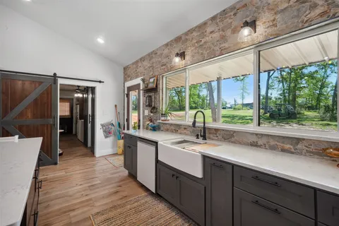 a kitchen with a sink and wooden floor