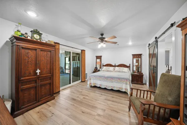 a spacious bedroom with a bed and dresser with mirror