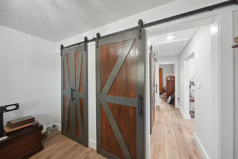 a view of a hallway with wooden floor and staircase