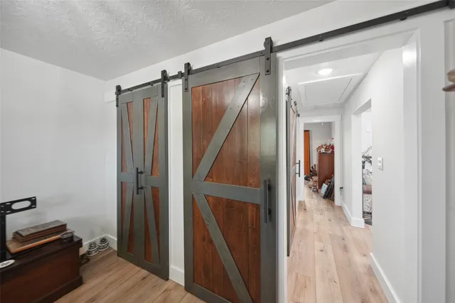 a view of a hallway with wooden floor and staircase