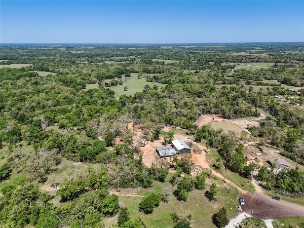 an aerial view of residential houses with outdoor space and trees