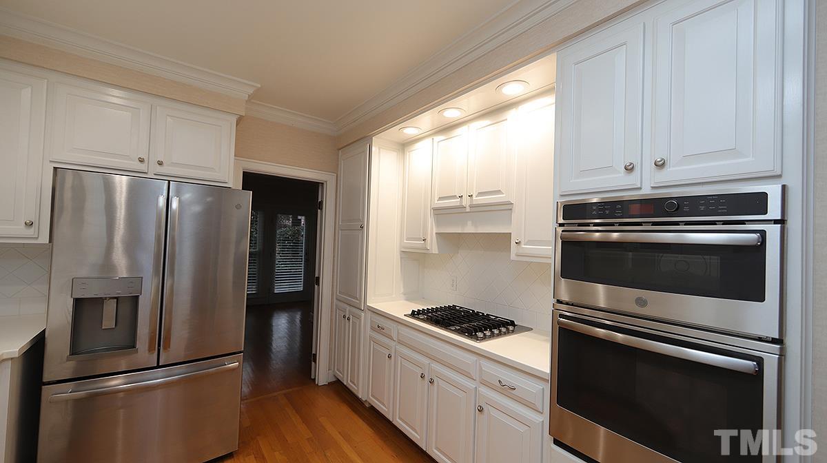 2203 Landings Way Raleigh, NC 27615 - Photo 5 of 22 a kitchen with a refrigerator stove and white cabinets