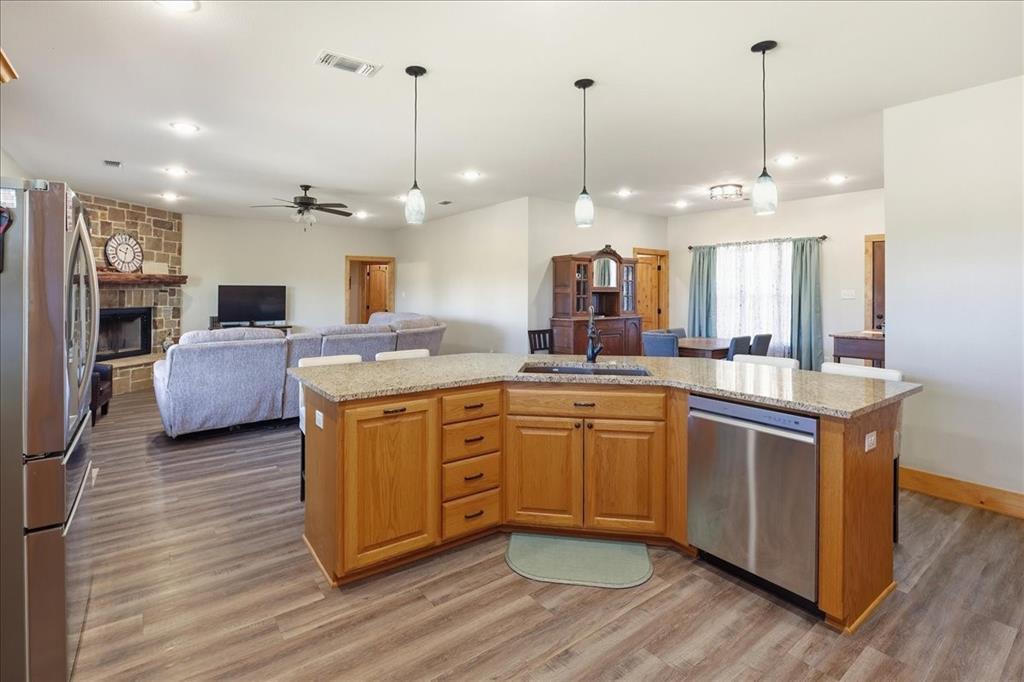 971 Bamboo Road Big Sandy, TX 75755 - Photo 14 of 40 a kitchen with kitchen island granite countertop wooden floors and wide window