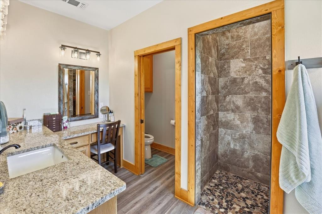 971 Bamboo Road Big Sandy, TX 75755 - Photo 19 of 40 a bathroom with a granite countertop sink a mirror and shower