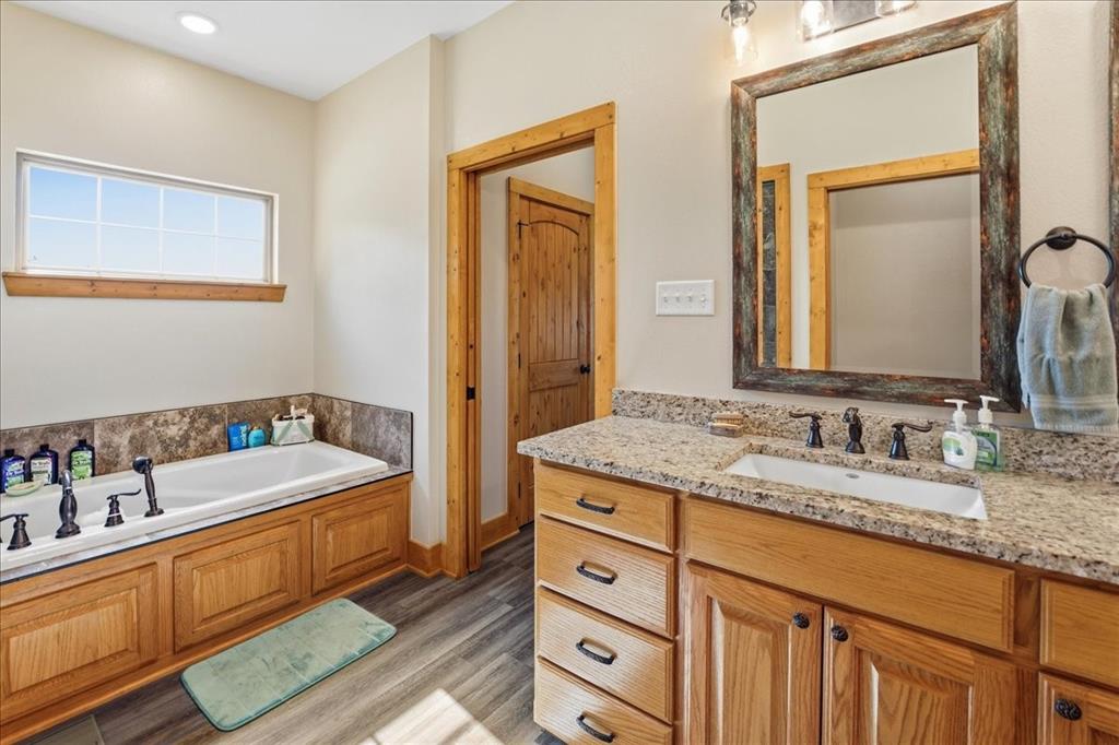971 Bamboo Road Big Sandy, TX 75755 - Photo 20 of 40 a bathroom with a tub double vanity sink and a mirror