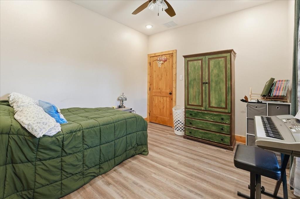 971 Bamboo Road Big Sandy, TX 75755 - Photo 21 of 40 a bedroom with a bed and a chandelier