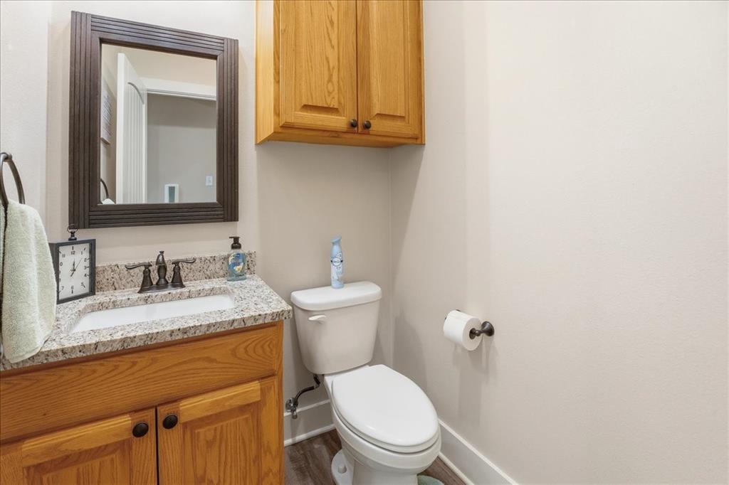 971 Bamboo Road Big Sandy, TX 75755 - Photo 33 of 40 a bathroom with a granite countertop toilet sink and mirror