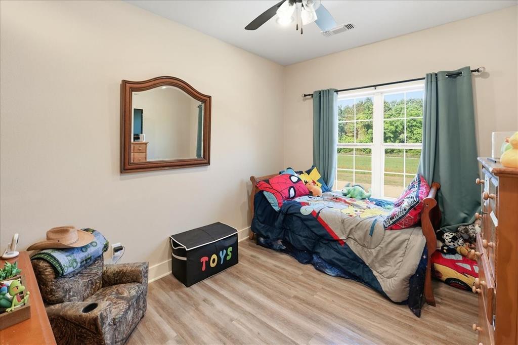 971 Bamboo Road Big Sandy, TX 75755 - Photo 34 of 40 a bedroom with a bed and wooden floor