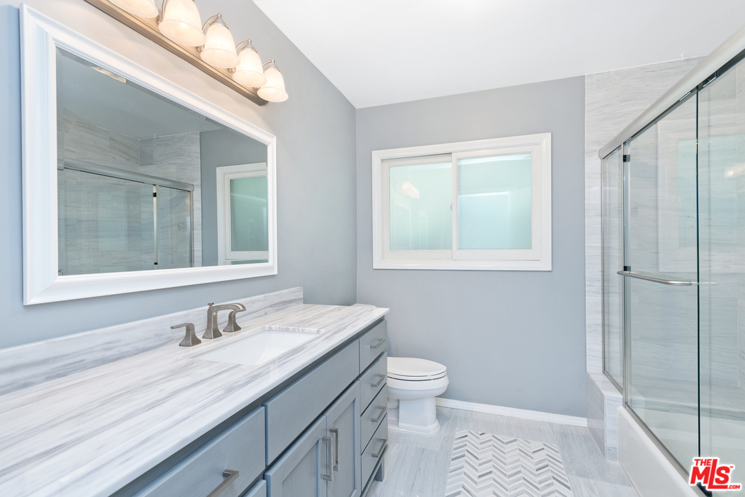 9614 Heather Road Beverly Hills, CA 90210 - Photo 11 of 26 a bathroom with a granite countertop sink toilet and shower