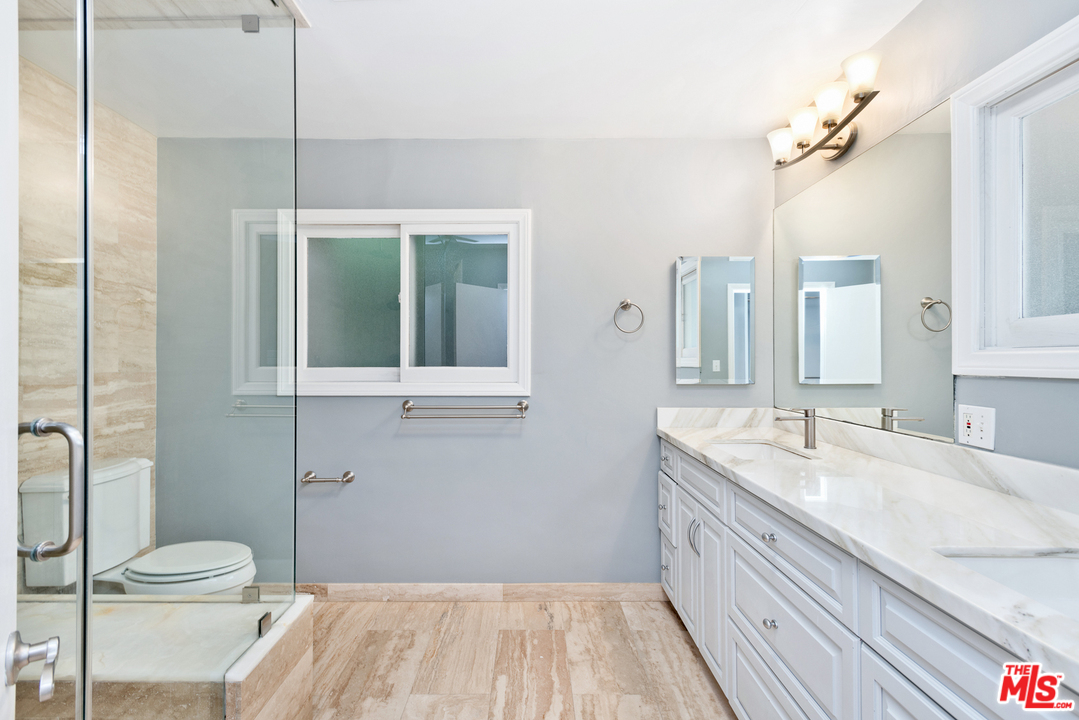 9614 Heather Road Beverly Hills, CA 90210 - Photo 15 of 26 a bathroom with a sink a toilet and a large mirror
