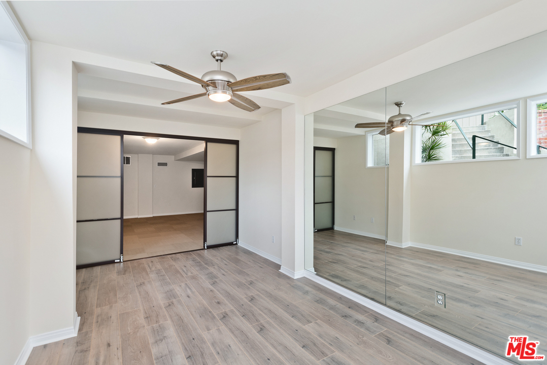 9614 Heather Road Beverly Hills, CA 90210 - Photo 18 of 26 a view of empty room with wooden floor and fan