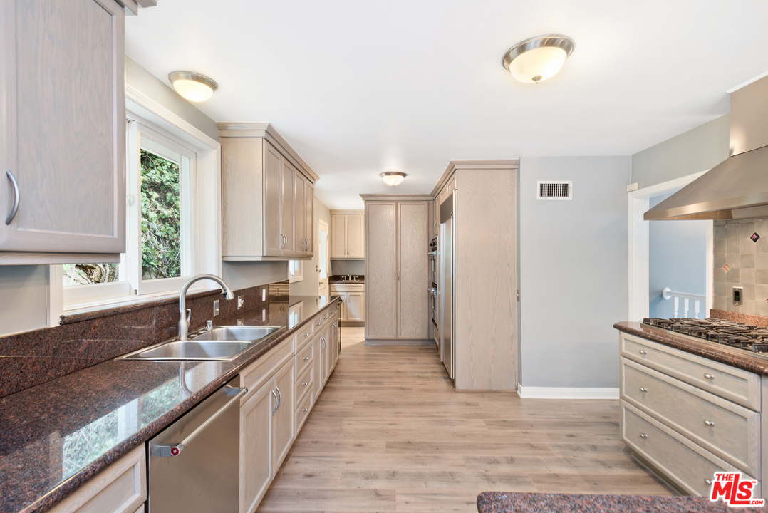 9614 Heather Road Beverly Hills, CA 90210 - Photo 5 of 26 a kitchen with a stove a sink and a refrigerator