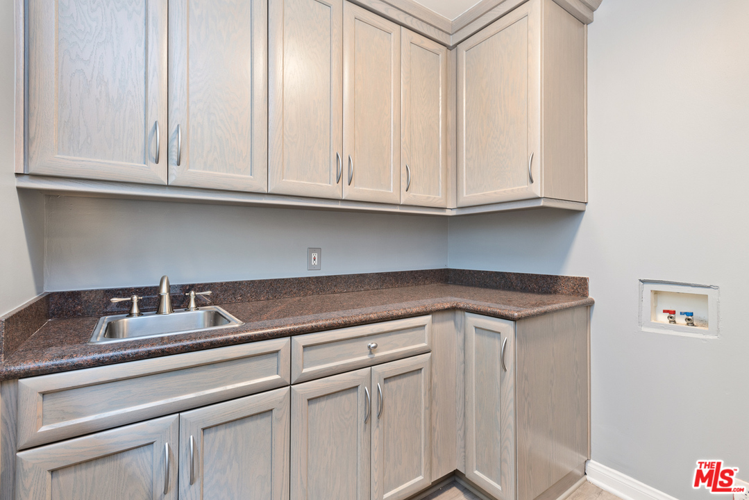 9614 Heather Road Beverly Hills, CA 90210 - Photo 8 of 26 a kitchen with white cabinets and a sink