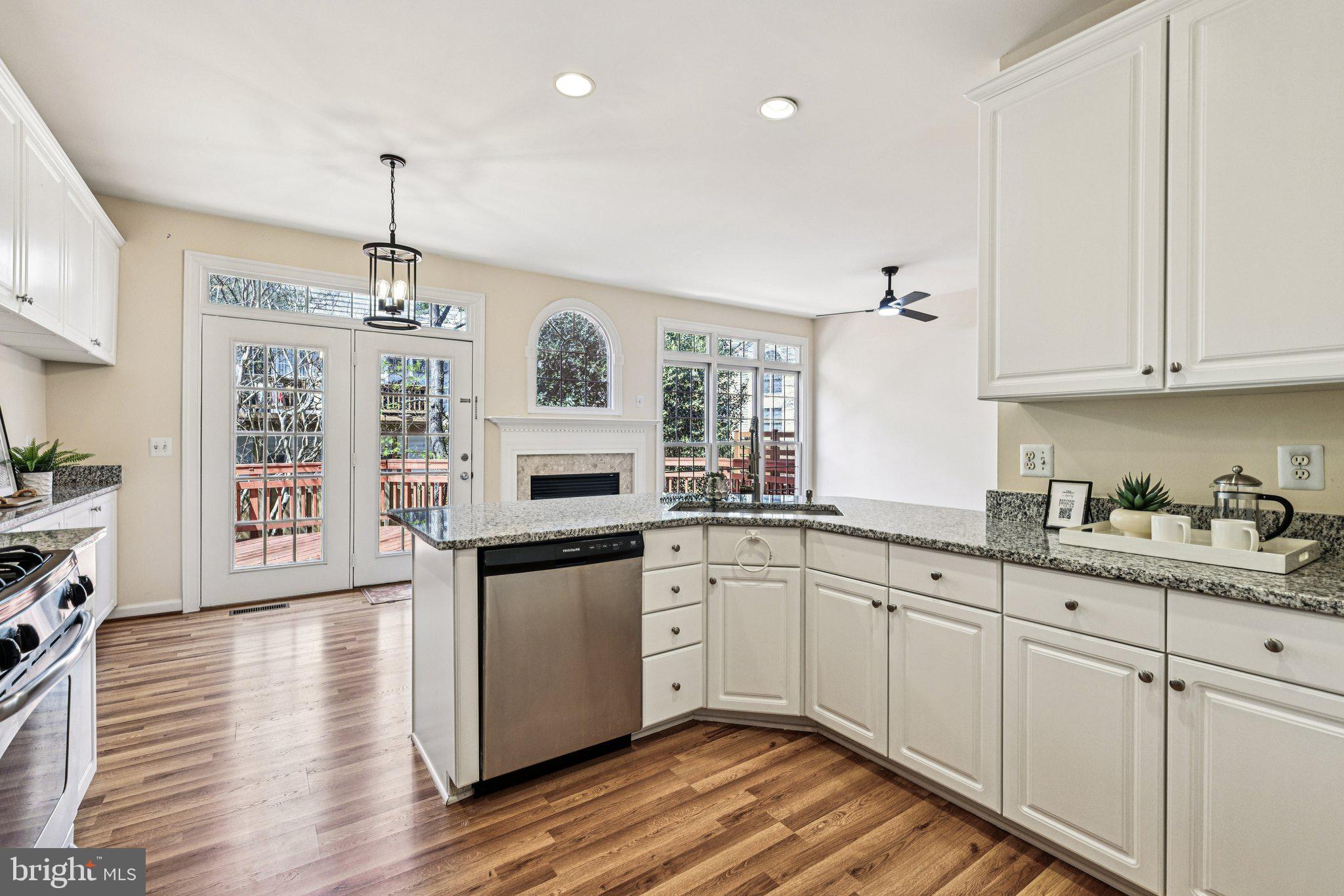 2746 Pembsly Drive Vienna, VA 22181 - Photo 14 of 46 a kitchen with stainless steel appliances granite countertop a stove a sink dishwasher and white cabinets with wooden floor