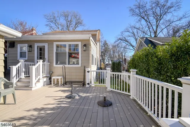a view of a house with a small yard and wooden floor and fence