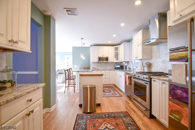 a kitchen with a stove sink cabinets and wooden floor